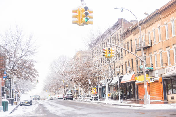 December 21, 2024: Brooklyn, NY, USA - On a cold winter morning snow covers the sidewalk and trees of the Park Slope neighborhood street lined with businesses and apartment buildings.