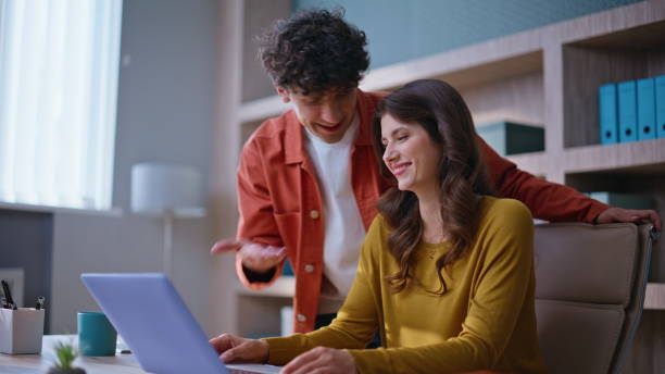 istock Smiling colleagues video calling by laptop in modern office space closeup. 2196989611