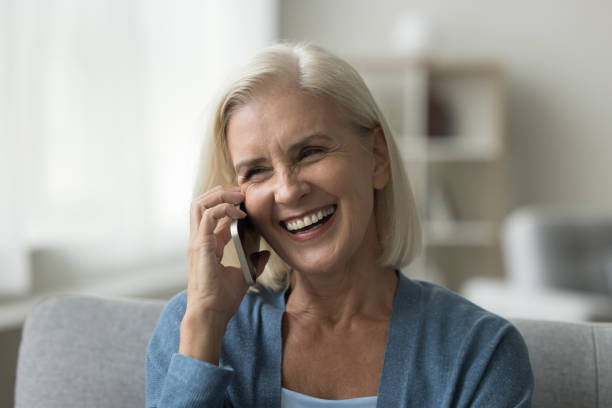 istock Happy mature woman enjoys mobile phone conversation 2196989798