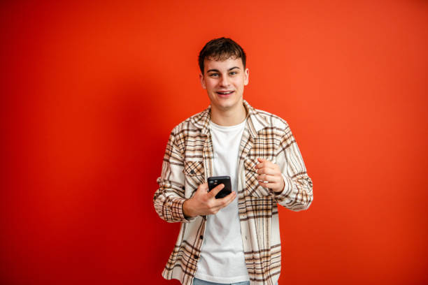 istock young man use mobile phone stand in front red background studio shot 2196991426