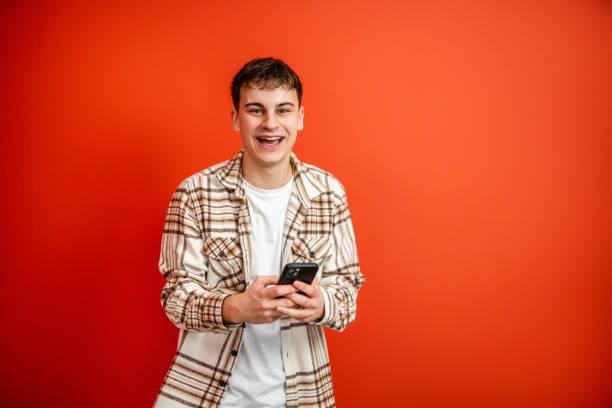 istock young man use mobile phone stand in front red background studio shot 2196991583