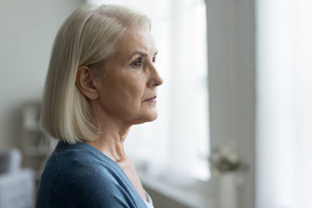 istock Pensive senior woman looking out window, close up side view 2196991641