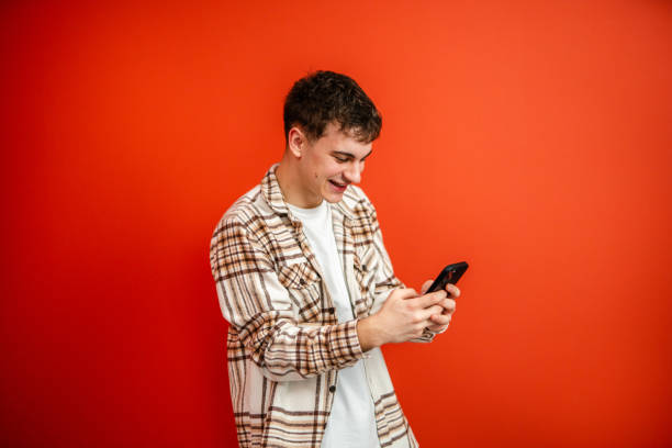 istock young man use mobile phone stand in front red background studio shot 2196991675