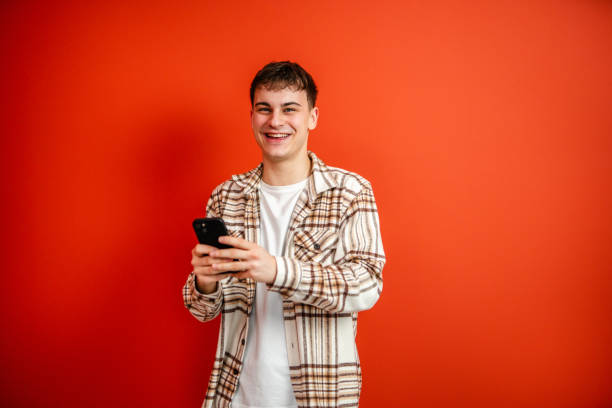 istock young man use mobile phone stand in front red background studio shot 2196991741