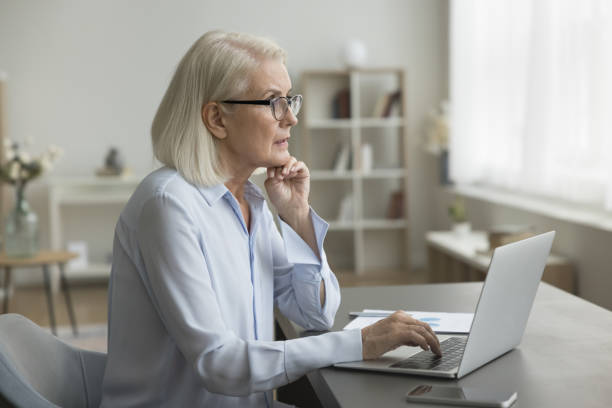 istock Serious thoughtful businesswoman engaged in workflow using laptop 2196991832