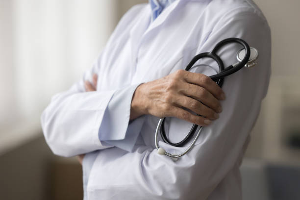 istock Closeup view unknown woman doctor in white coat holding stethoscope 2196991897