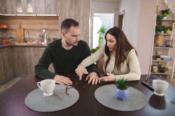 Couple arguing at home about their relationship problems Young couple arguing about their relationship problems while sitting at the kitchen table define the relationship​ stock pictures, royalty-free photos & images