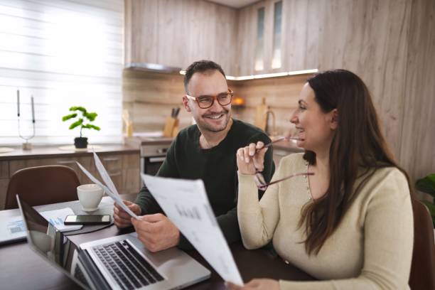 istock Couple analyzing financial documents at home with laptop 2196993603