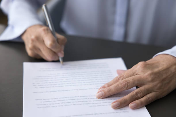 istock Older female signing business document, close up view 2196993825