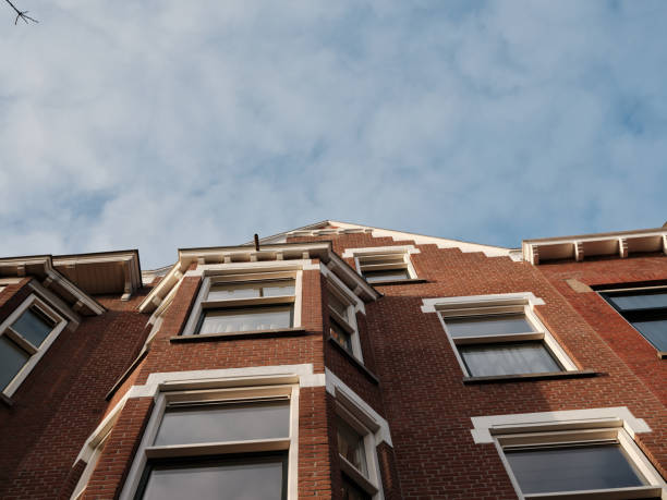 istock Looking up at traditional brick apartment building under blue sky 2196993918