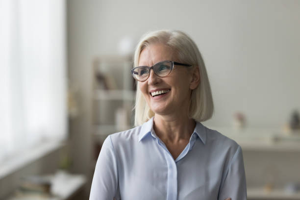 istock Attractive mature businesslady or teacher laughing standing alone at workplace 2196993992