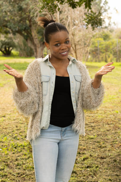 istock Black woman shrugging with a playful expression outdoors 2196994429