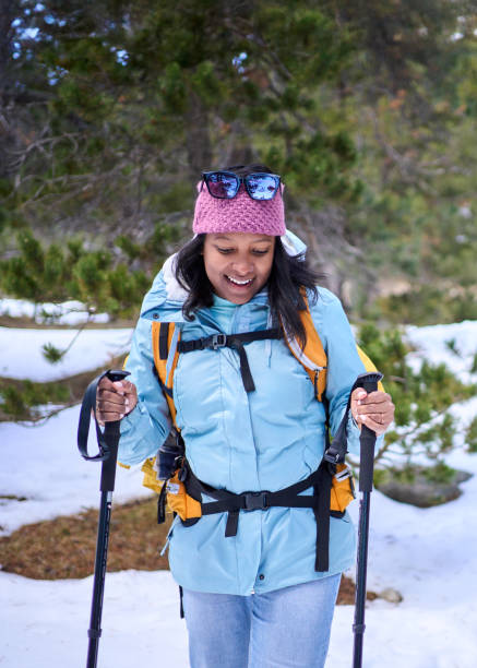 istock Hiker walking in snowy mountain forest trail with backpack and trekking poles 2197001172