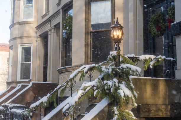 istock Illuminated Lantern with Snow Covered Garland by Stoop in Brooklyn NY 2197002876