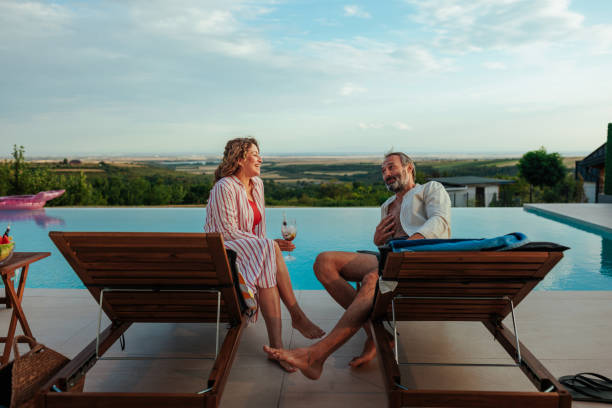 istock Man and a woman sitting on deck chairs and talking cheerfully 2197003296