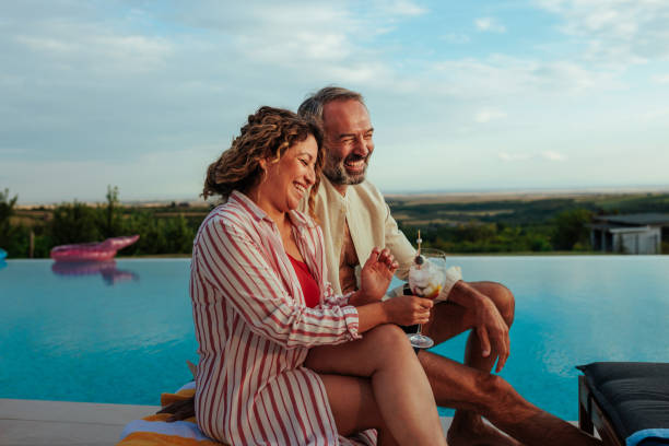 Middle-aged couple relaxing by a pool