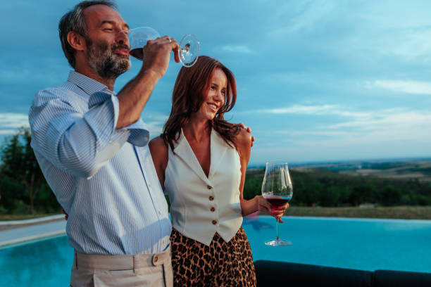 istock Couple enjoying wine by infinity pool at sunset 2197003332