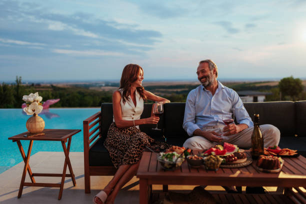 istock Couple enjoying wine and appetizers by infinity pool at sunset 2197003338