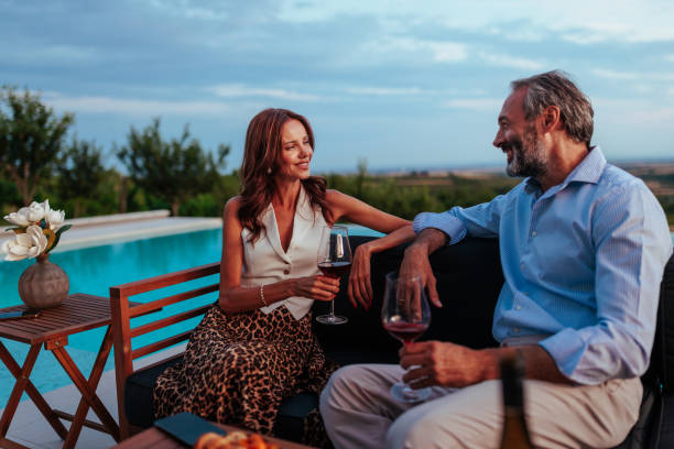 istock Couple enjoying wine by the pool during a relaxing evening 2197003339