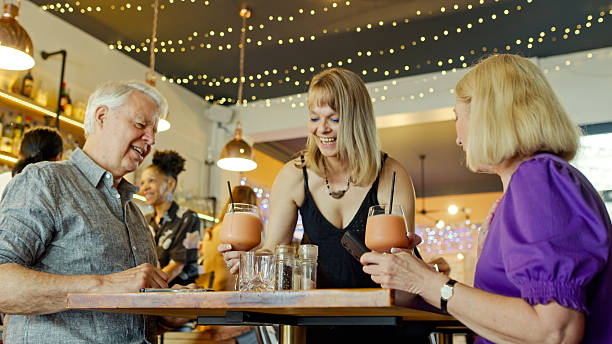 istock Waitress Brings Two Mature Adults a Pair of Blended Drinks 2197003572