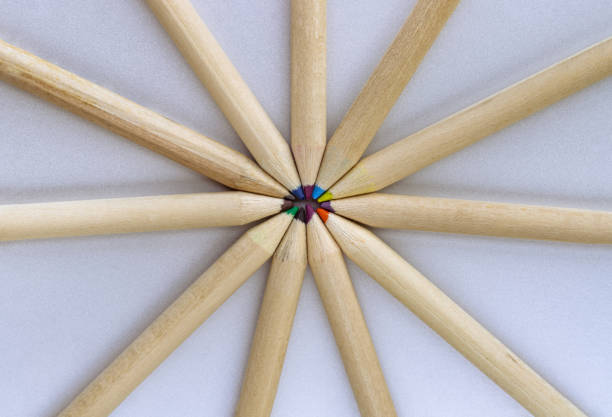Top view of Brown crayons arranged in a circle on silver background. Wooden colored pencils come together and circle, An artistic display of colored pencils, Stationery for drawing, Minimalism art supplies concept, Empty space for text, design and wallpaper, Selective focus.