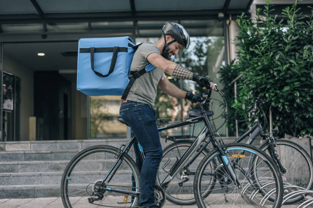 istock Delivery Cyclist Secures Bike in Urban Setting 2197013703