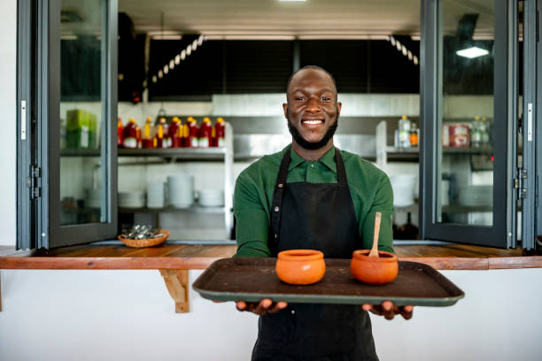 istock Smiling Male Chef Holding Traditional Clay Pots in Modern Kitchen 2197013783