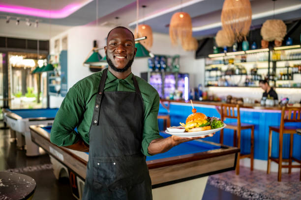 istock Smiling Chef Presenting Delicious Burger in Trendy Restaurant 2197013817