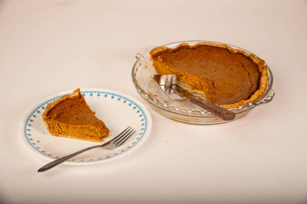 Slice of delicious pumpkin pie next to pie plate ready to eat.