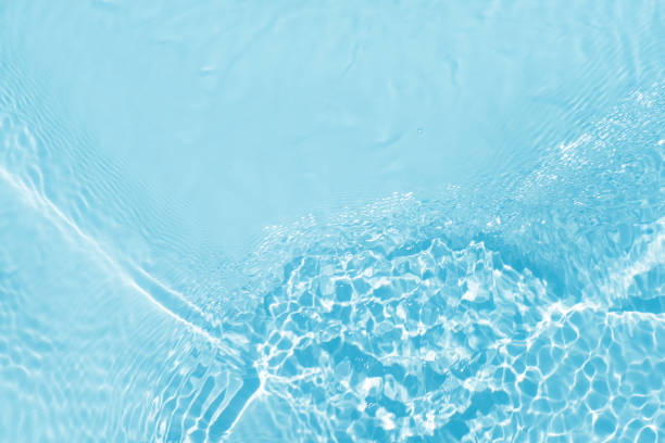 istock Blue water with ripples on the surface. Defocus blurred transparent blue colored clear calm water surface texture with splashes and bubbles. Water waves with shining pattern texture background. 2197017515