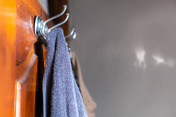 Stock photo capturing a hotel bedroom's tranquility with neatly folded white towels, bed sheets, quilt, and pillow. Ample copyspace invites hotel promotions or hospitality-themed designs, showcasing comfort and cleanliness in a relaxing accommodation setting