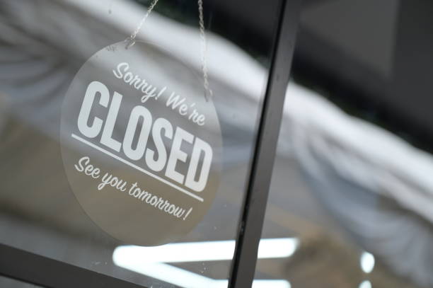 istock Store closed sign hanging on the window 2197023846