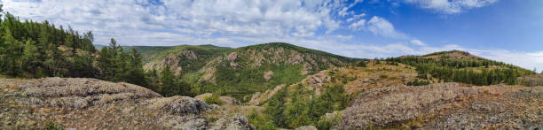 istock The image appears blurred, depicting a beautiful mountain landscape that features lush trees and an expansive blue sky above, creating a serene and natural environment full of life 2197025047