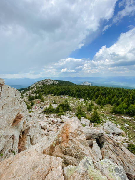 istock A diverse group gathers at a mountain summit, admiring the breathtaking scenery and savoring the stunning natural landscape with a sense of wonder and appreciation for natures beauty 2197025092
