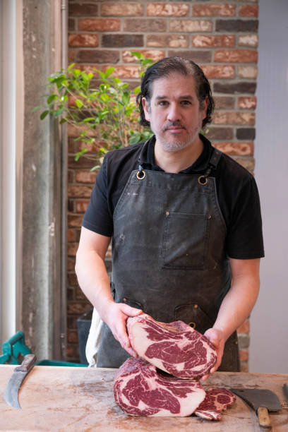 istock Portrait of butcher with steaks 2197035829