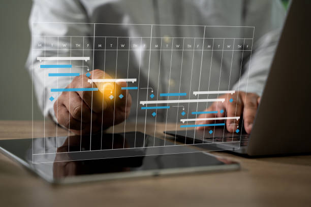 istock PROJECT MANAGEMENT businessman using a cell phone and laptop to view a project plan 2197039555
