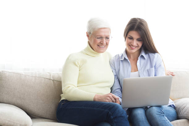 istock Woman teaching mother how to use laptop computer 2197039736