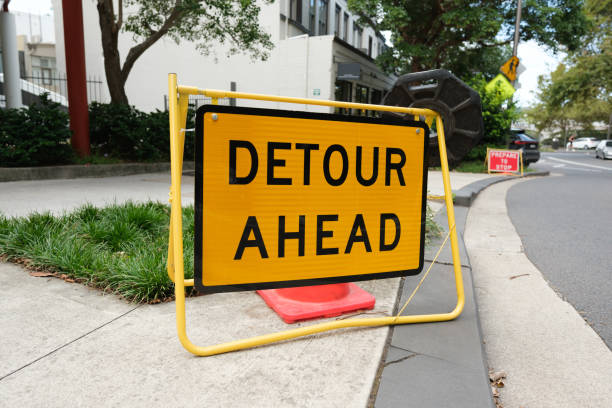 Orange metal detour ahead road sign.