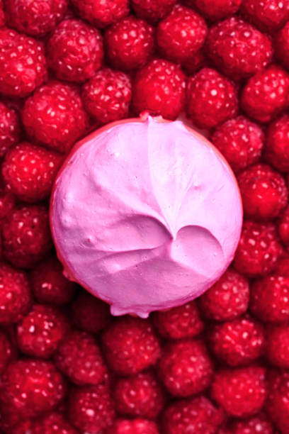 istock A vibrant and appetizing composition featuring a single pink marshmallow nestled among a bed of fresh raspberries. The contrasting colors and textures create a visually stunning image. 2197042012