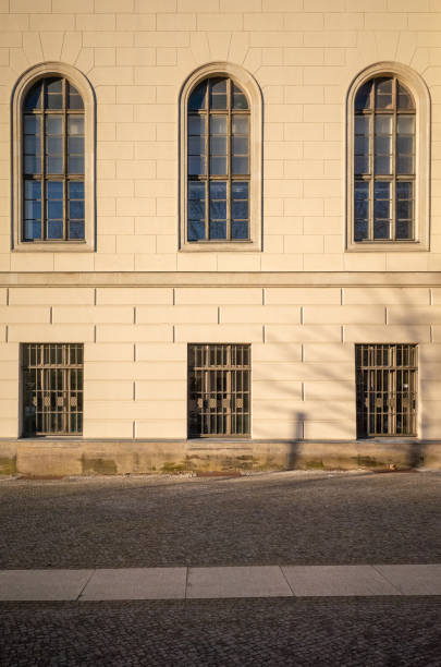 istock historic beige stone building with arched windows on the upper level and barred windows on the lower level, bathed in warm sunlight 2197042357