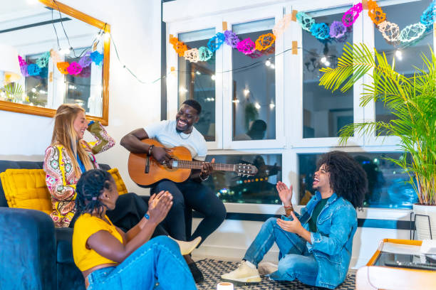 istock Friends joyfully singing and playing guitar at home party 2197044296