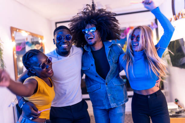 istock Four friends are having fun, taking a selfie and dancing at home party 2197044324