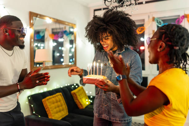 istock Friends clapping and singing happy birthday at party 2197044377