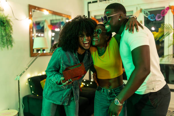 istock Friends celebrating with a gift at home party 2197044395