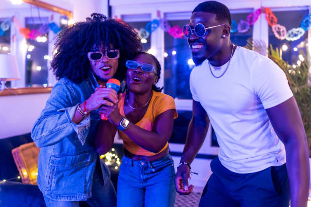 istock Three young adults singing karaoke at home party 2197044413