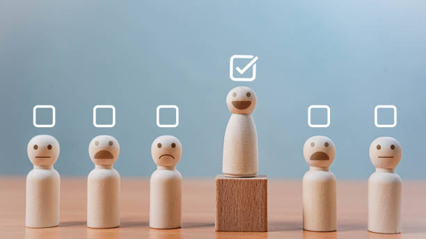 istock Employee Performance Evaluation and HR Selection. A smiling wooden figure stands elevated on a block with a checkmark. symbolizing selection, leadership, excellence, and customer satisfaction. 2197044581
