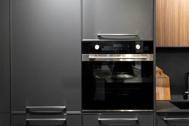 istock Built-in oven with sleek black finish and control knobs in minimalist kitchen 2197048463