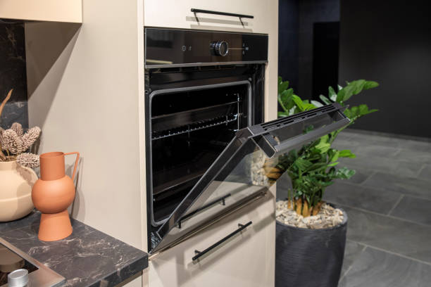istock Open door oven in beige kitchen interior with decorative accents 2197048919
