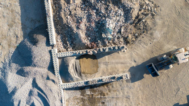 Aerial view of a construction site with a large pile of rubble and a bulldozer.