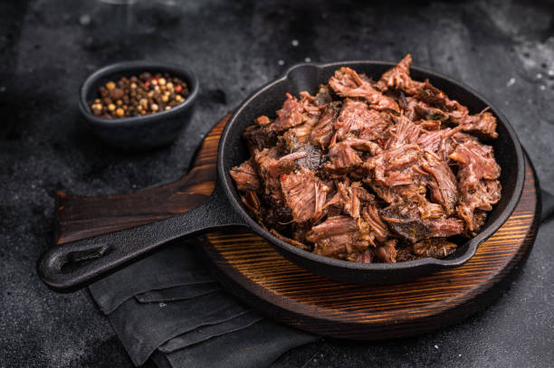 istock Traditional barbecue pulled beef, Slow cooked meat cooked in a smoker. black background. top view 2197055579